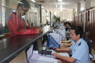 Công chức Hải quan cảng Sài Gòn khu vực 1 làm thủ tục cho DN ngày thứ Bảy 24-12. Ảnh: Thu Hòa